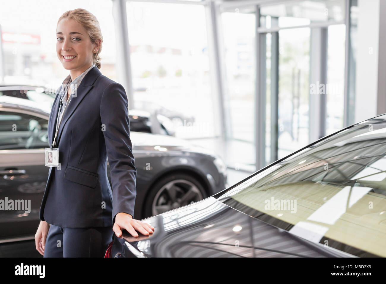 Portrait confident car saleswoman in car dealership showroom Stock Photo