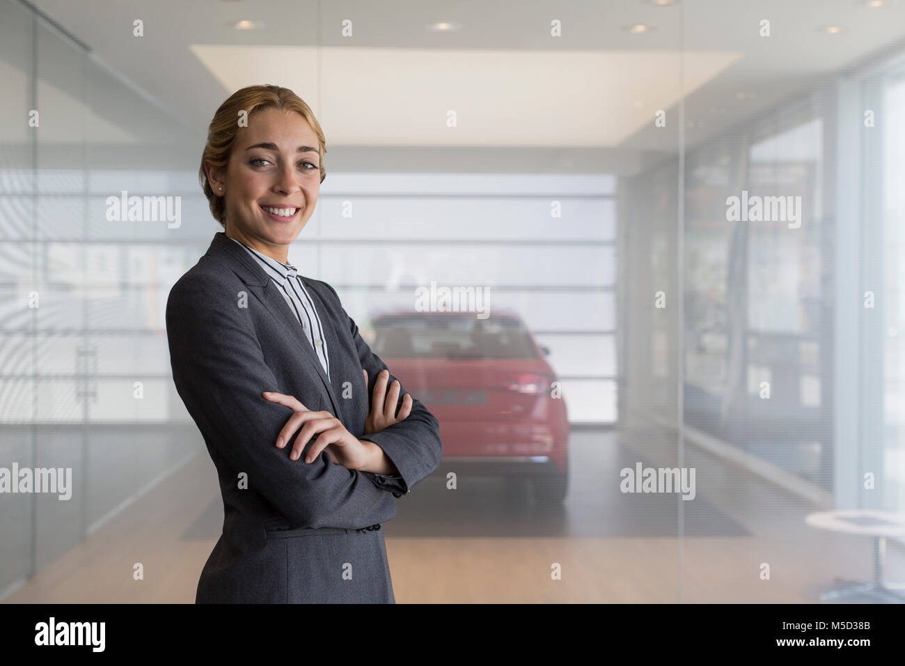 Portrait smiling, confident car saleswoman in car dealership showroom Stock Photo