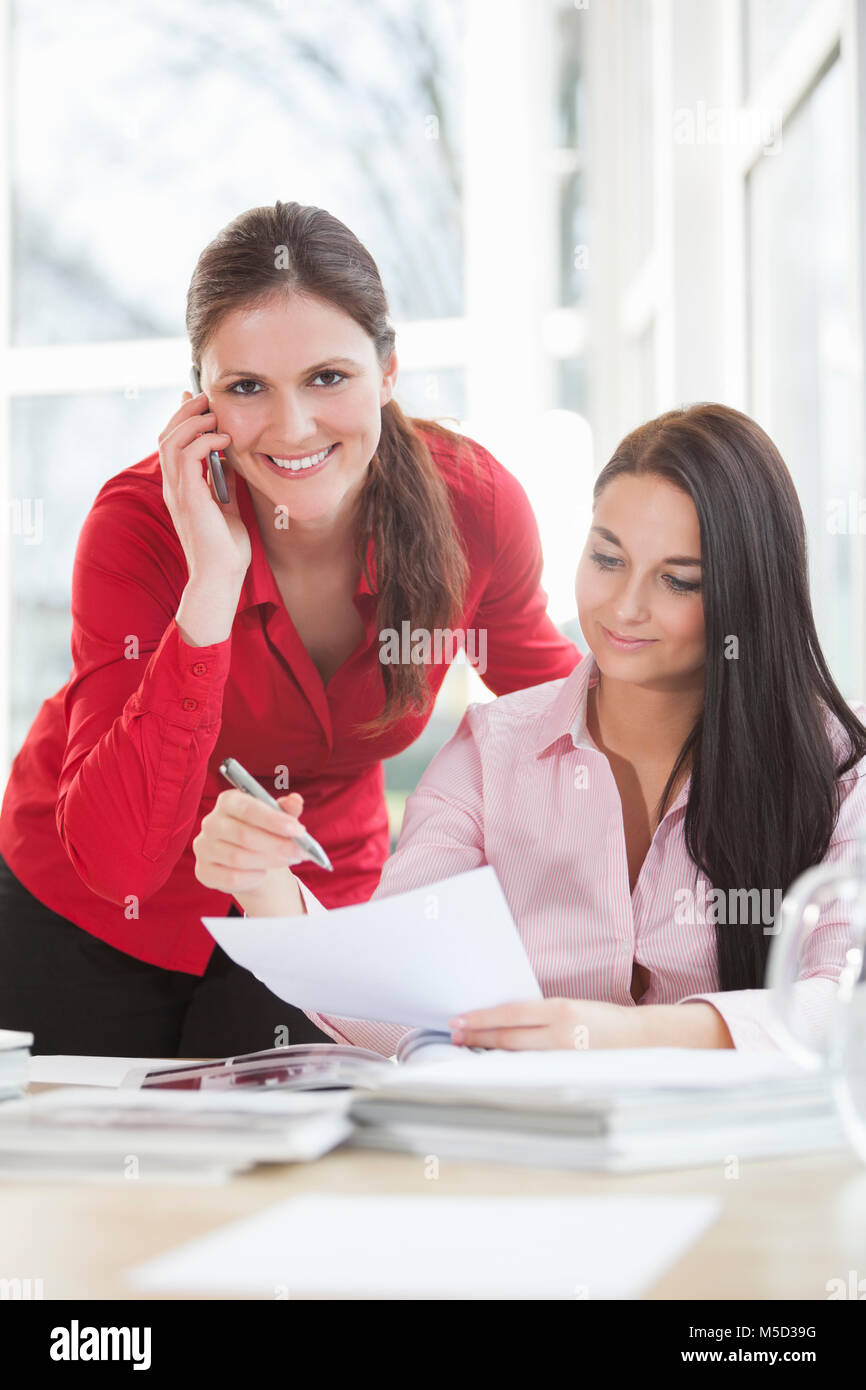 Beautiful young businesswomen working at office desk Stock Photo - Alamy