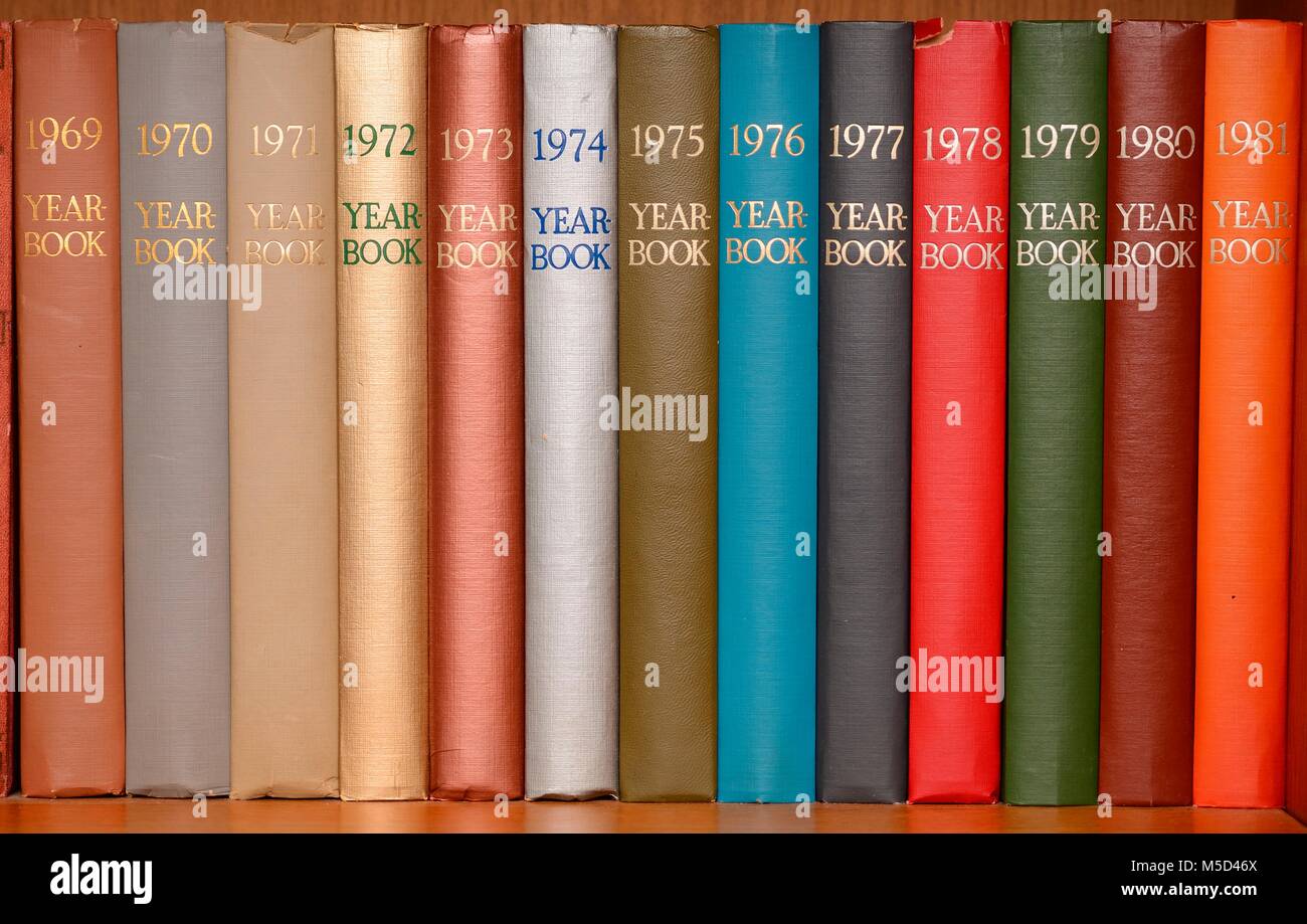 Year-books in different colors in a shelf Stock Photo