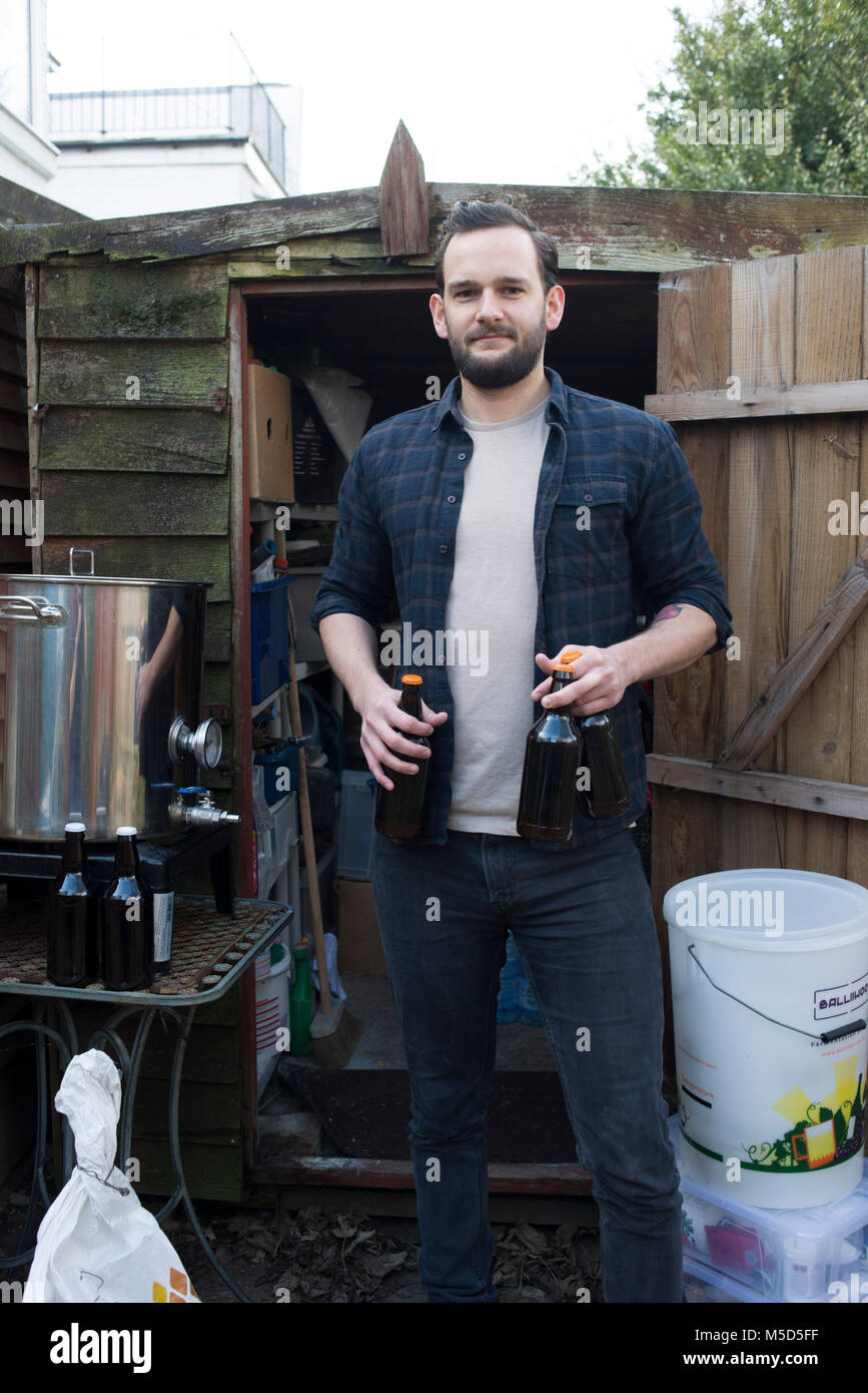 home brewers stand proudly with their home made beer and ale in their houses Stock Photo