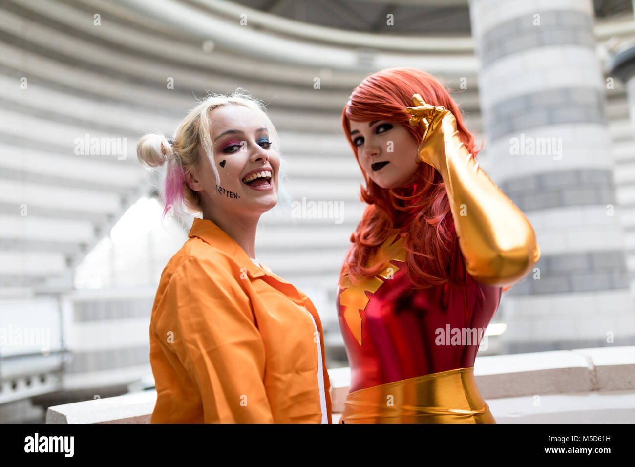 Doncaster Comic Con 11th Feruary 2018 at The Doncaster Dome UK. Two young women cosplay as Harley Quinn Suicidé Squad and Marvel’s Jean Grey Phoenix Stock Photo