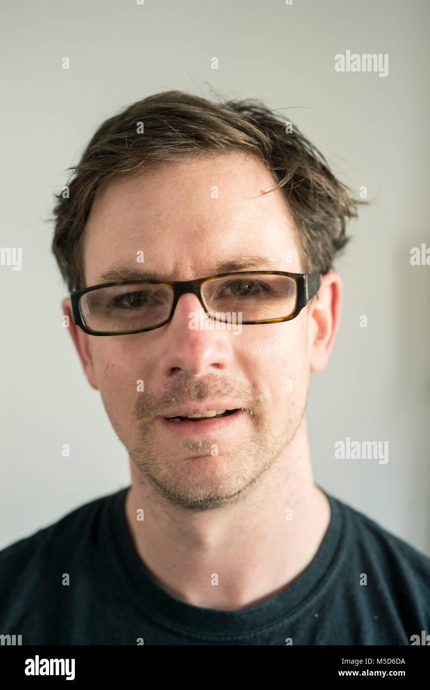 a head shot of a man who is looking at the camera and wearing a dark black t shirt Stock Photo