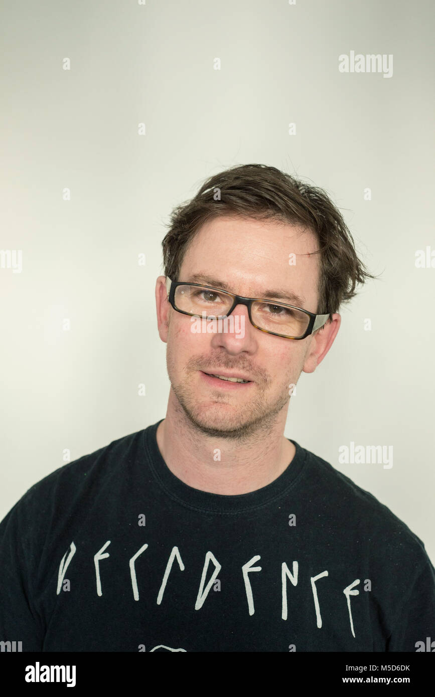 a head shot of a man who is looking at the camera and wearing a dark black t shirt Stock Photo