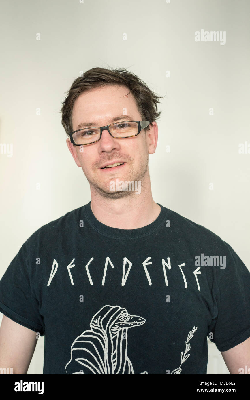 a head shot of a man who is looking at the camera and wearing a dark black t shirt Stock Photo