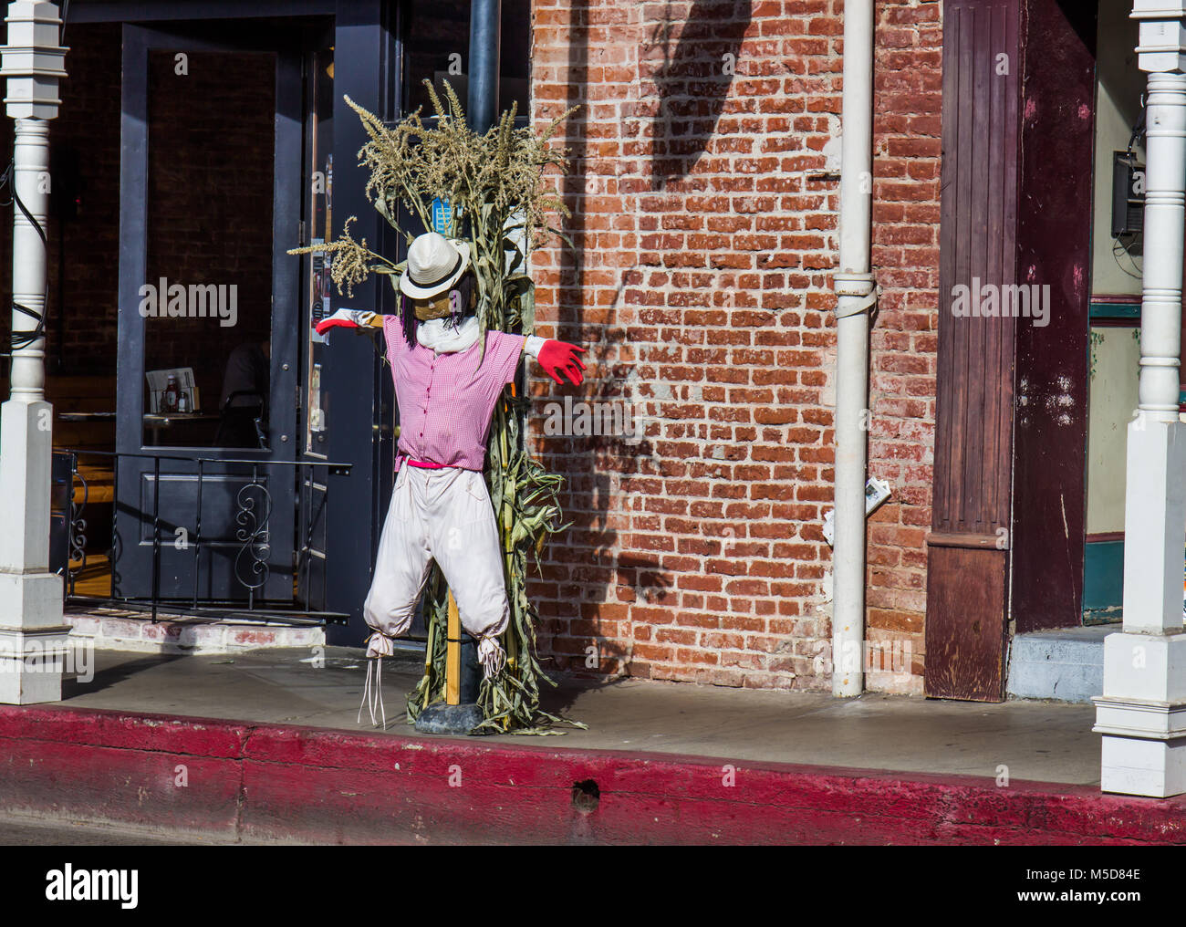Halloween Scarecrow Decorating Street Post In Small Town Stock Photo