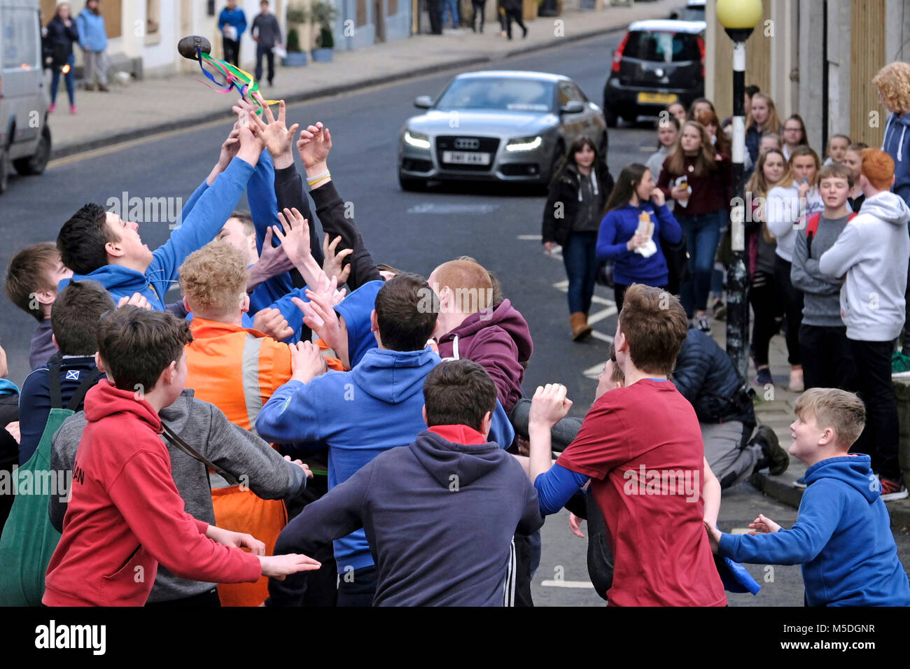 Jedburgh, Mercat Cross, UK. 22nd Feb, 2018. Jed Hand Ba' The annual game of hand ball takes place every year the Thursday after Fastern's E'en. The tradition derives from 1548 when a party of Scots recaptured Ferniehirst Castle, a mile south of Jedburgh and used an Englishman's head in a celebratory game after the battle. the Schule Ba, the first to be thrown up at 12 noon, for the boys games ( Credit: Rob Gray/Alamy Live News Stock Photo