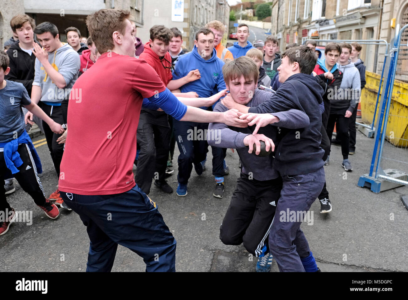 Jedburgh, Mercat Cross, UK. 22nd Feb, 2018. Jed Hand Ba' The annual game of hand ball takes place every year the Thursday after Fastern's E'en. The tradition derives from 1548 when a party of Scots recaptured Ferniehirst Castle, a mile south of Jedburgh and used an Englishman's head in a celebratory game after the battle. Trying to make a break with a ' Ba ' from the boys game ( Credit: Rob Gray/Alamy Live News Stock Photo