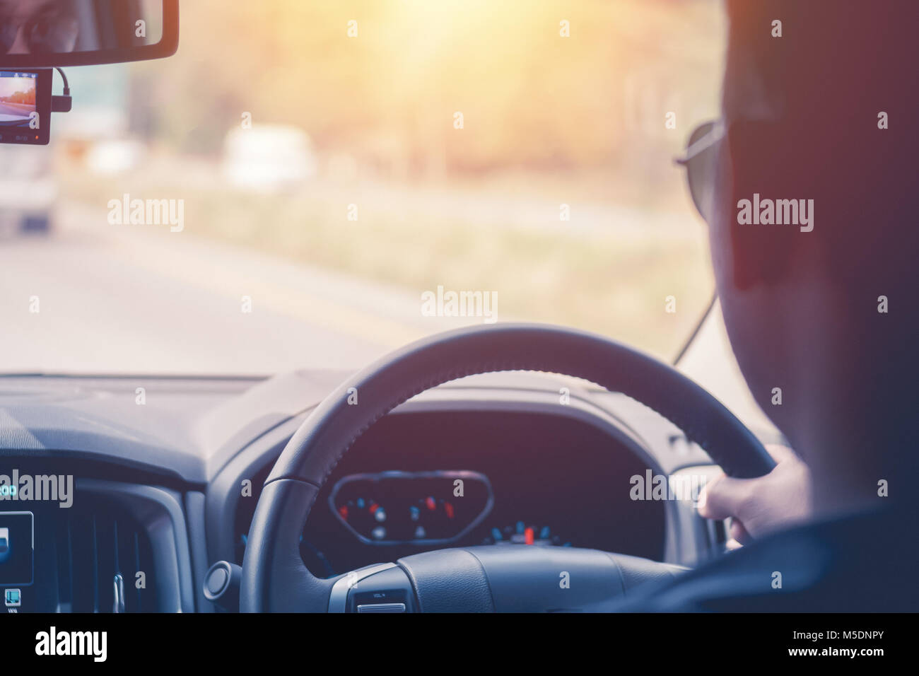 Driver hands holding steering wheel, inside of a car process warm vintage tone Stock Photo