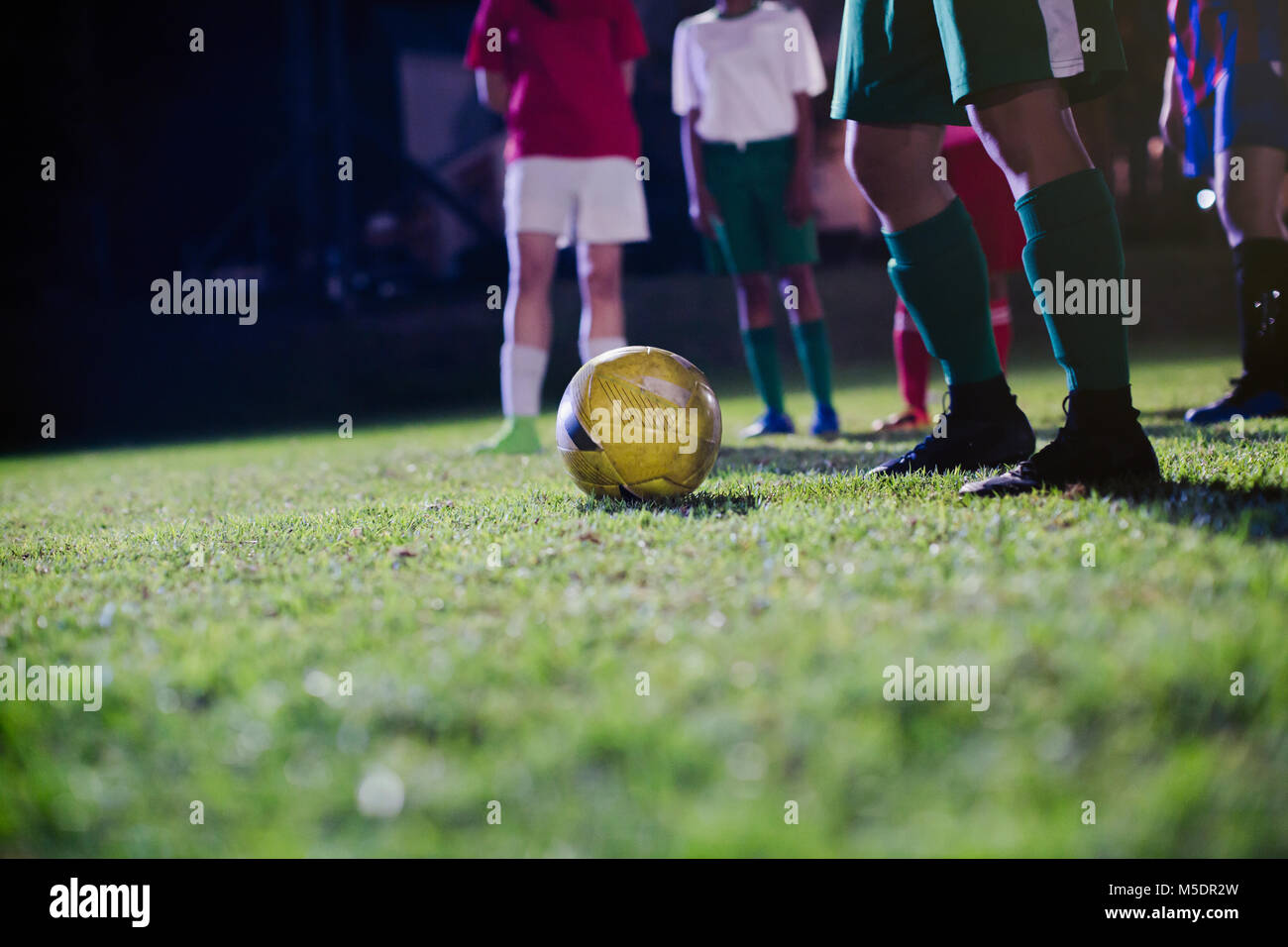 Young female soccer players practicing on field at night Stock Photo