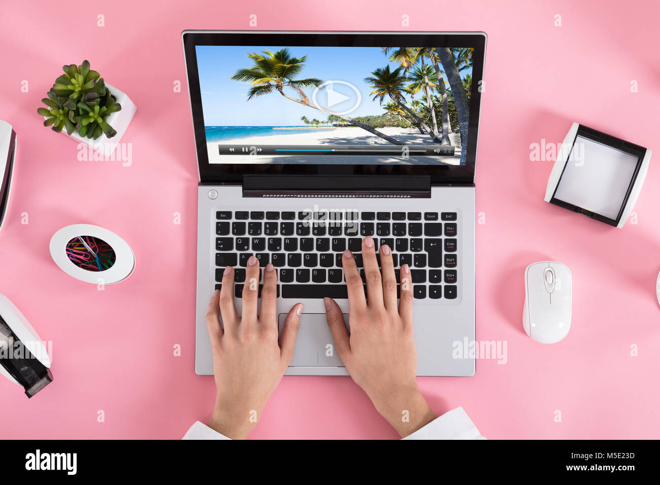 Close-up Of A Woman Watching Video On Laptop Over The Pink Desk At ...