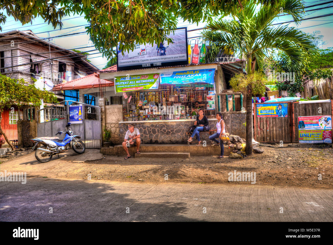 Tourists outside a local convenience store, sari sari, in Puerto Princesa, Palawan, Philippines. Stock Photo