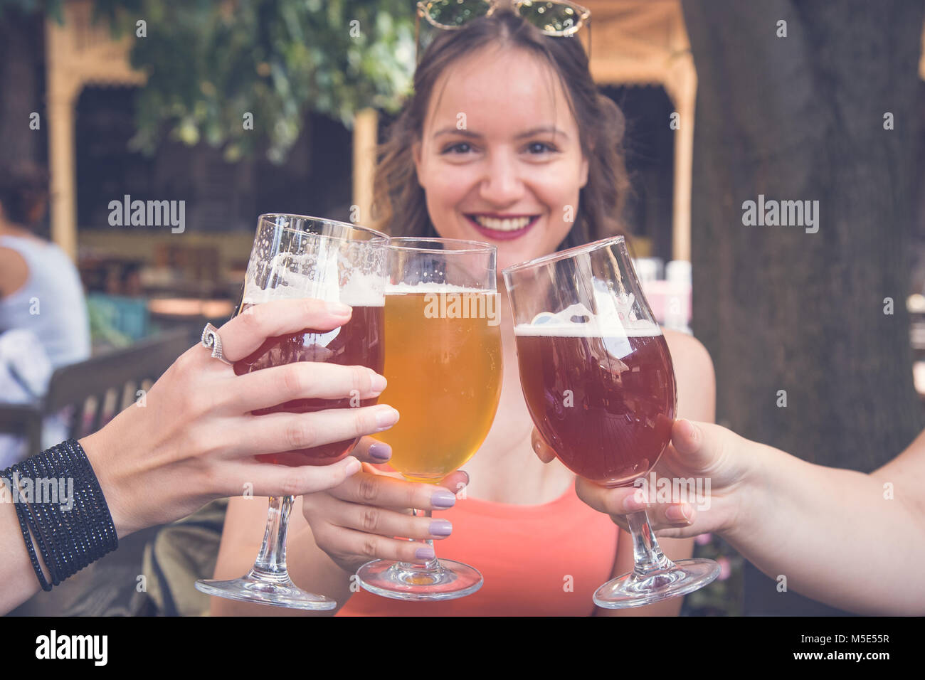 Female toasting and cheering aperitif beers half pint with her friends at restaurant Stock Photo