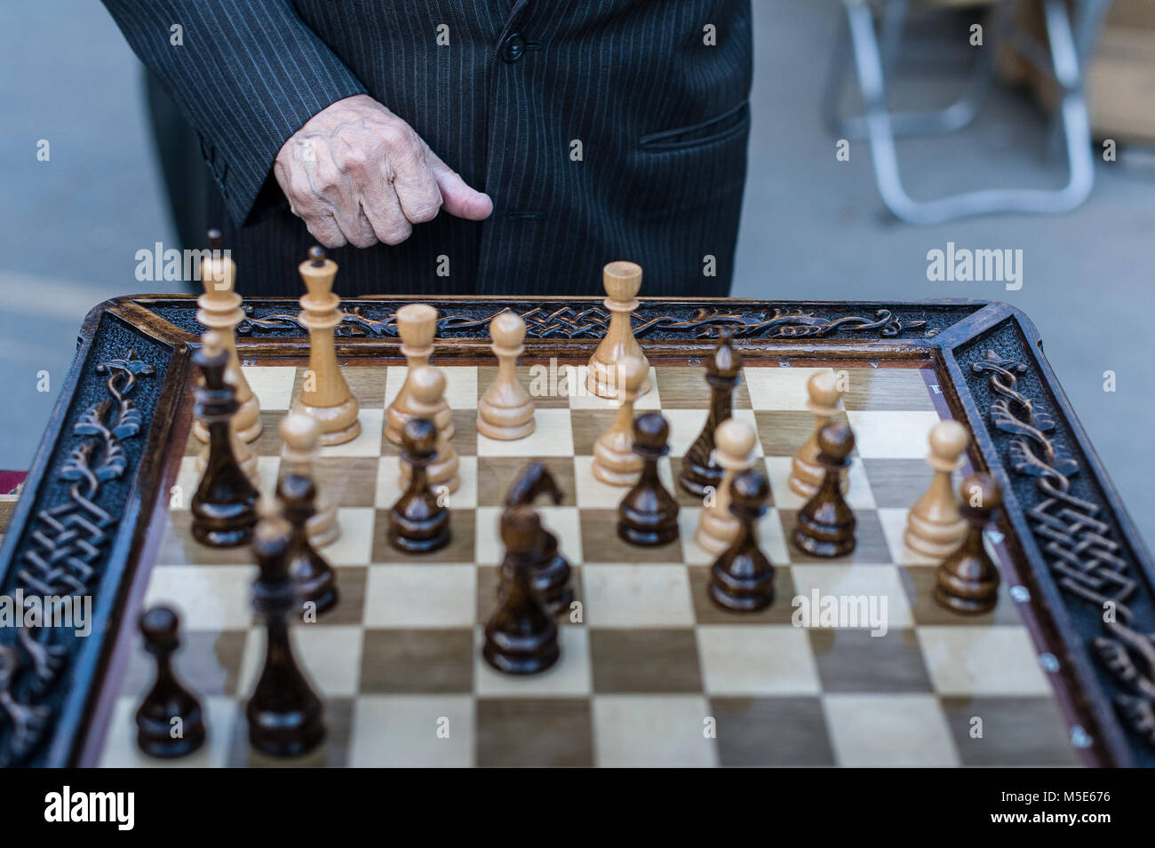 player playing his next move step on the vintage old chess board Stock  Photo - Alamy
