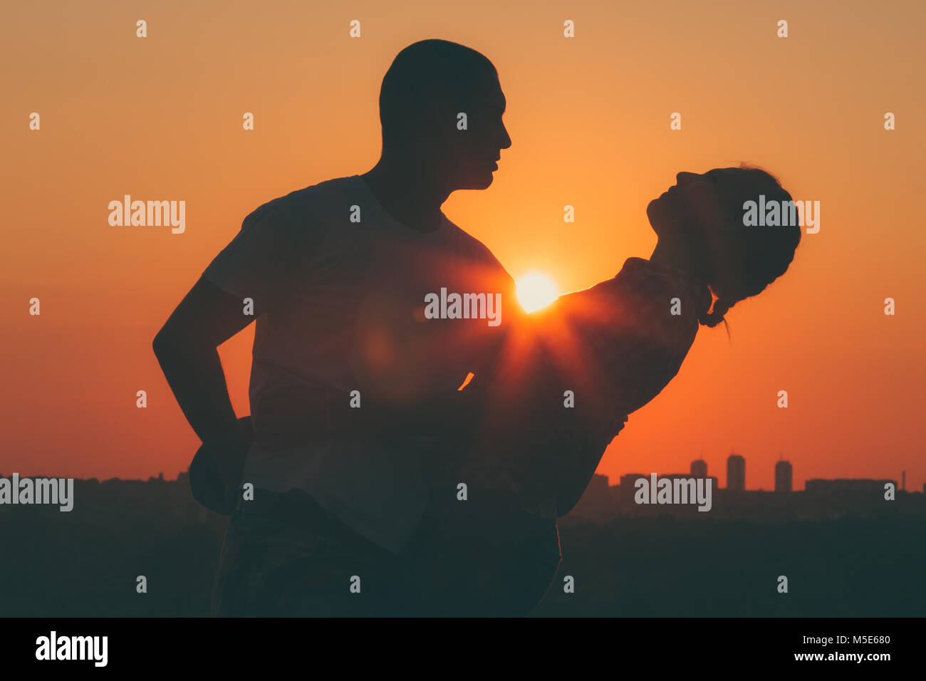 Silhouette of young couple in love dancing at sunset Stock Photo - Alamy