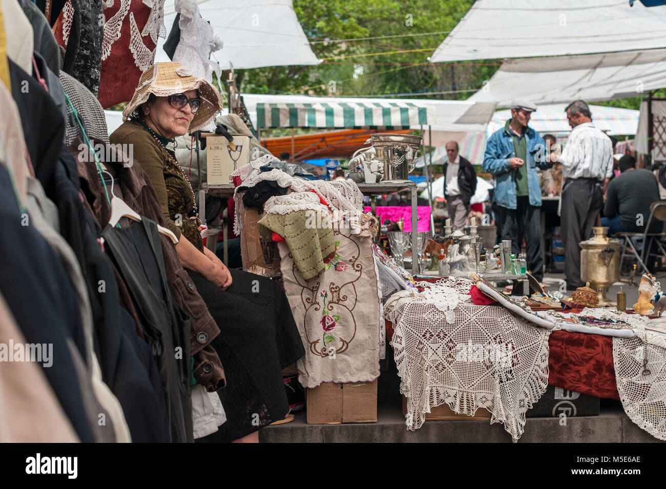 Old lady with hat, waiting for some customers at the flea market of Yerevan, Armenia. Stock Photo