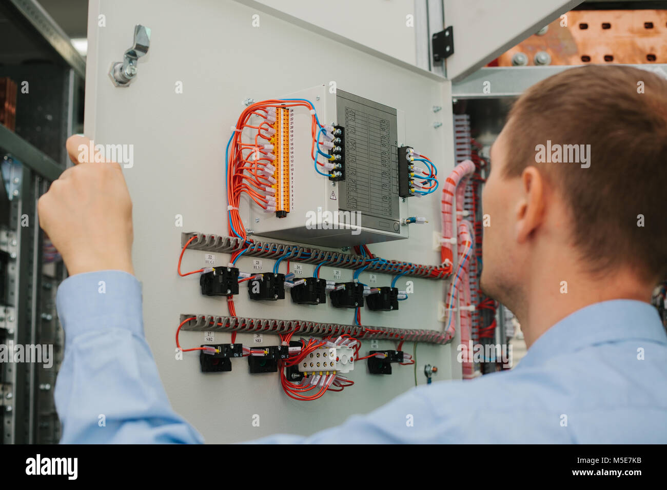 Electrician specialist checking low-voltage cabinet equipment Stock Photo