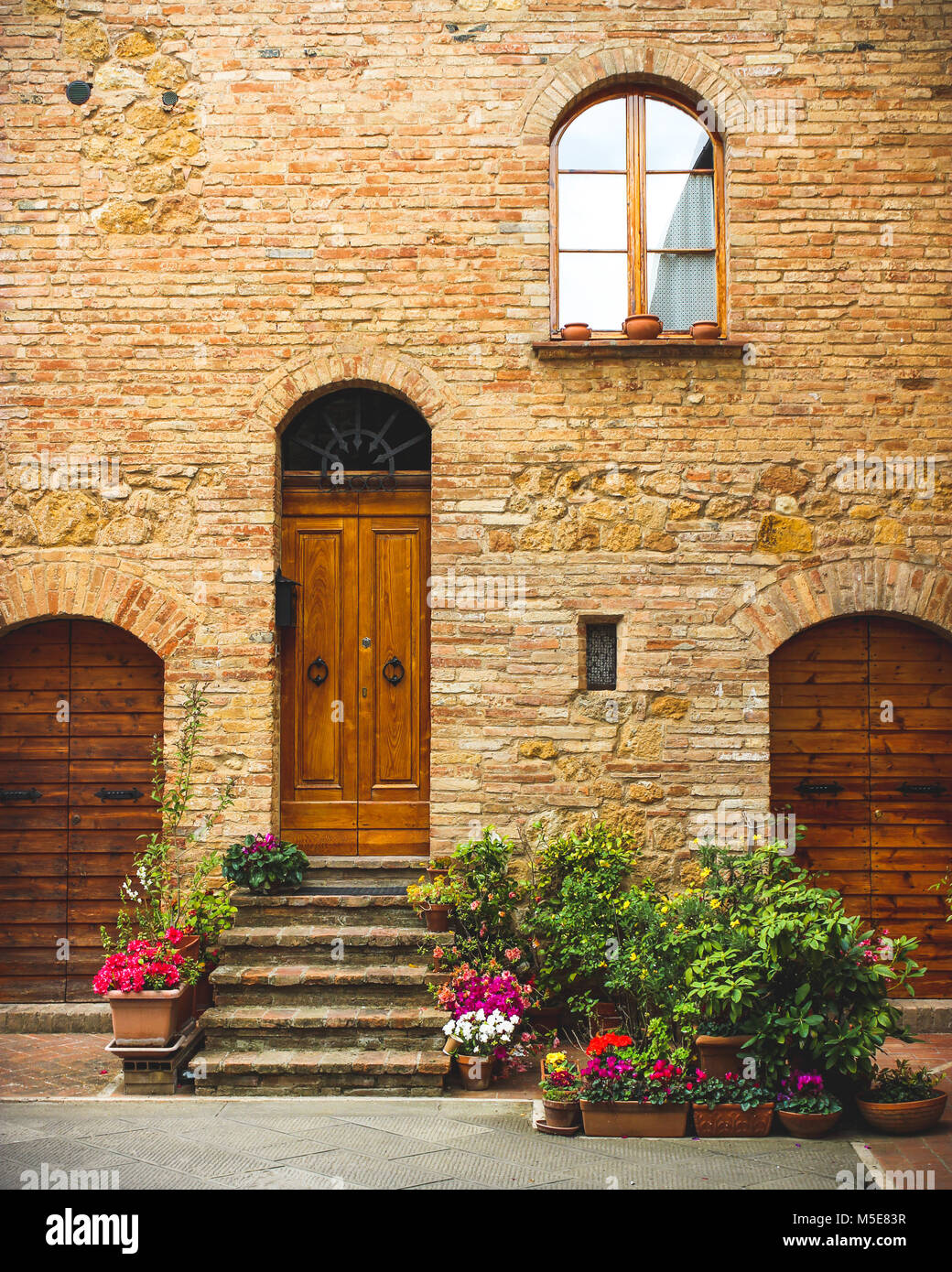 Flowers decorate the entrance of a house in ancient italian town Stock