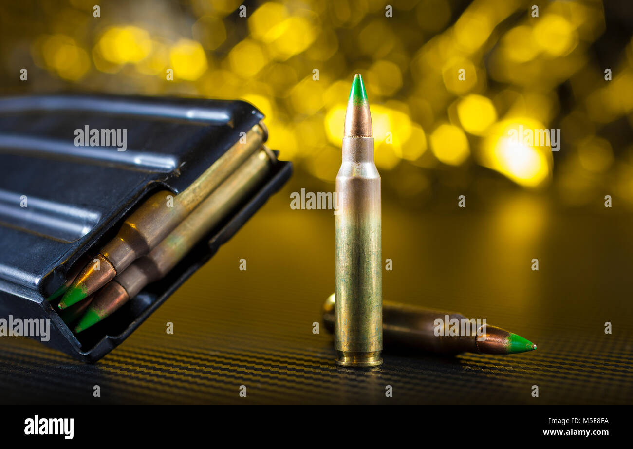 Loaded magazine and cartridges for an AR15 on a yellow background