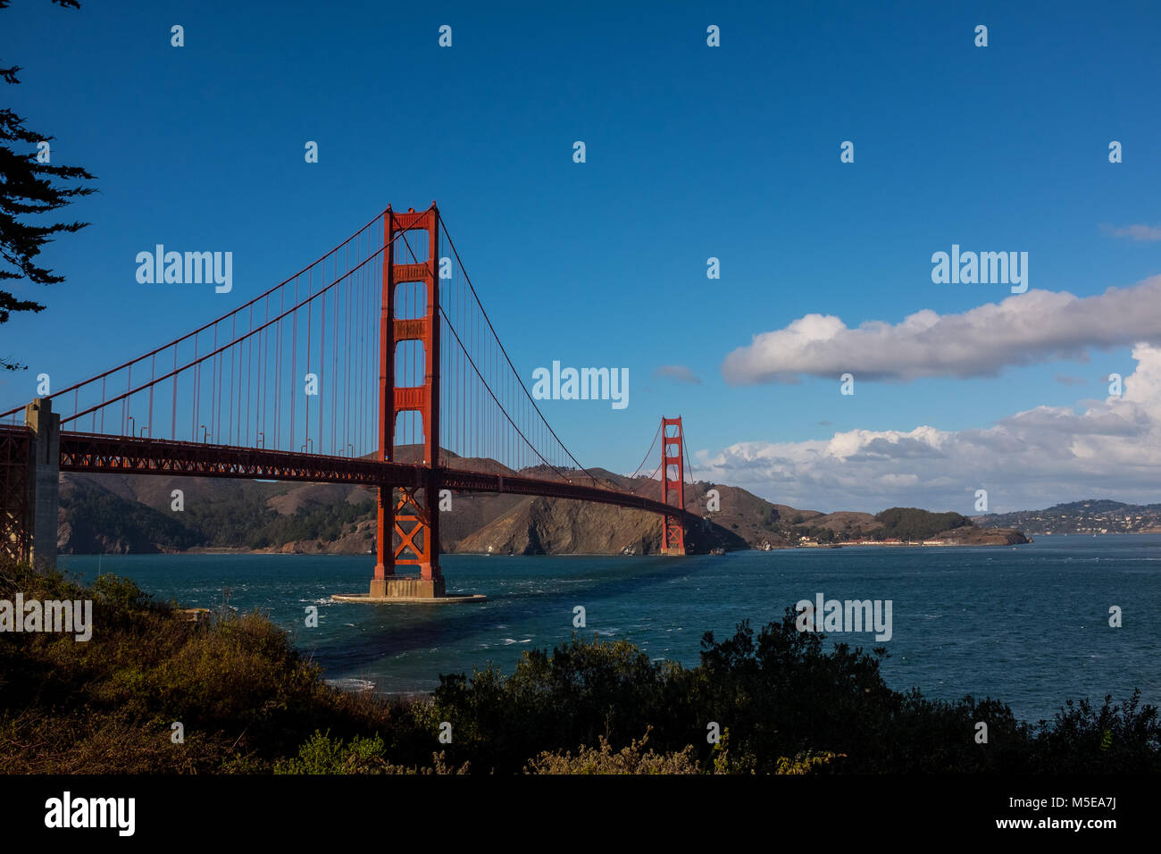 Golden Gate bridge on a sunny day with a blue sky and white clouds, San ...