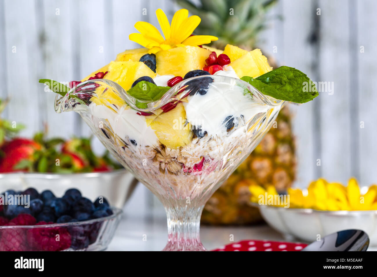 Fresh breakfast with muesli, yoghurt, fruit and edible flowers Stock