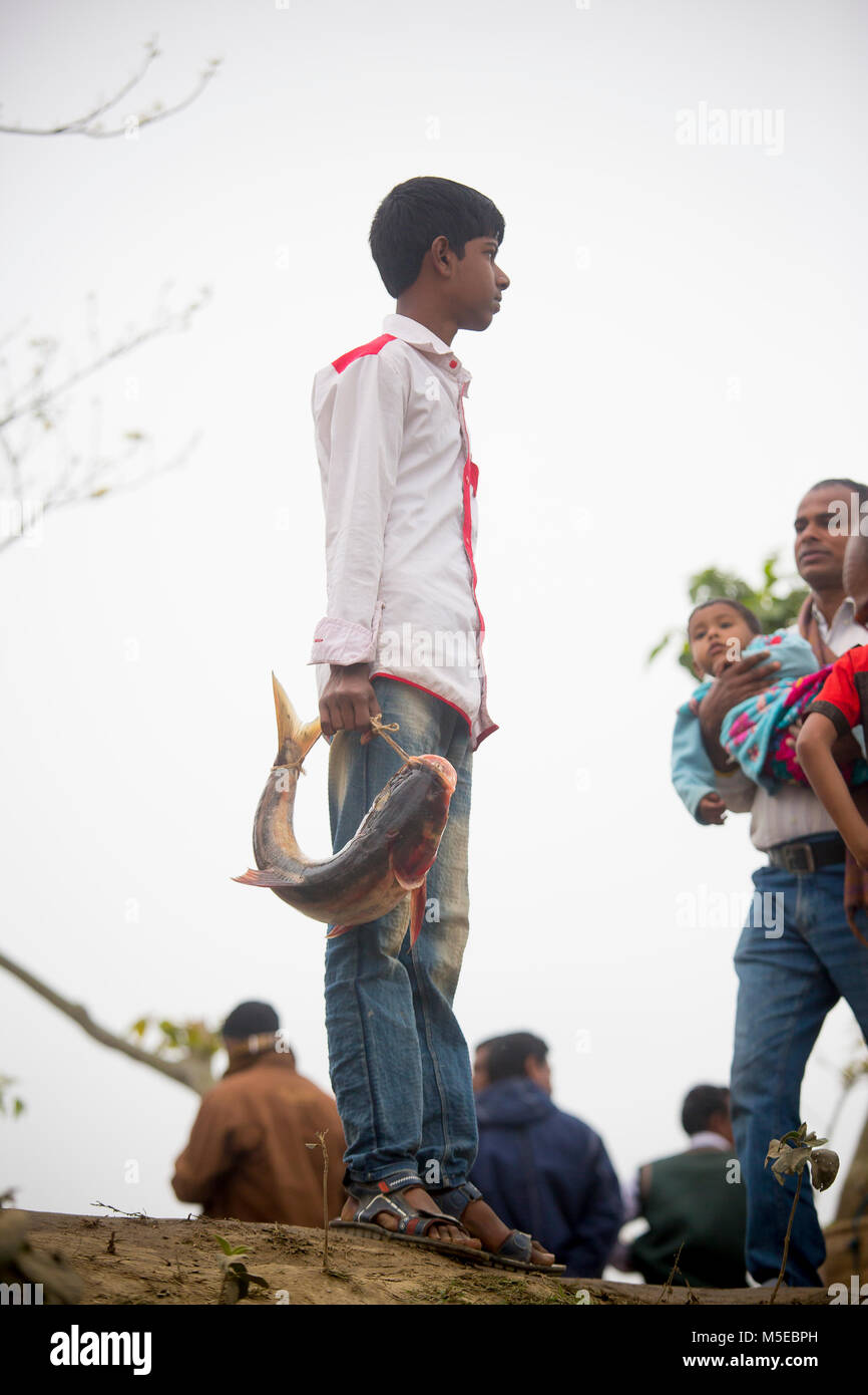 A young boy and his little brother is returning home after purchasing a fish from the fair (Poradah Mela) for the family. Stock Photo