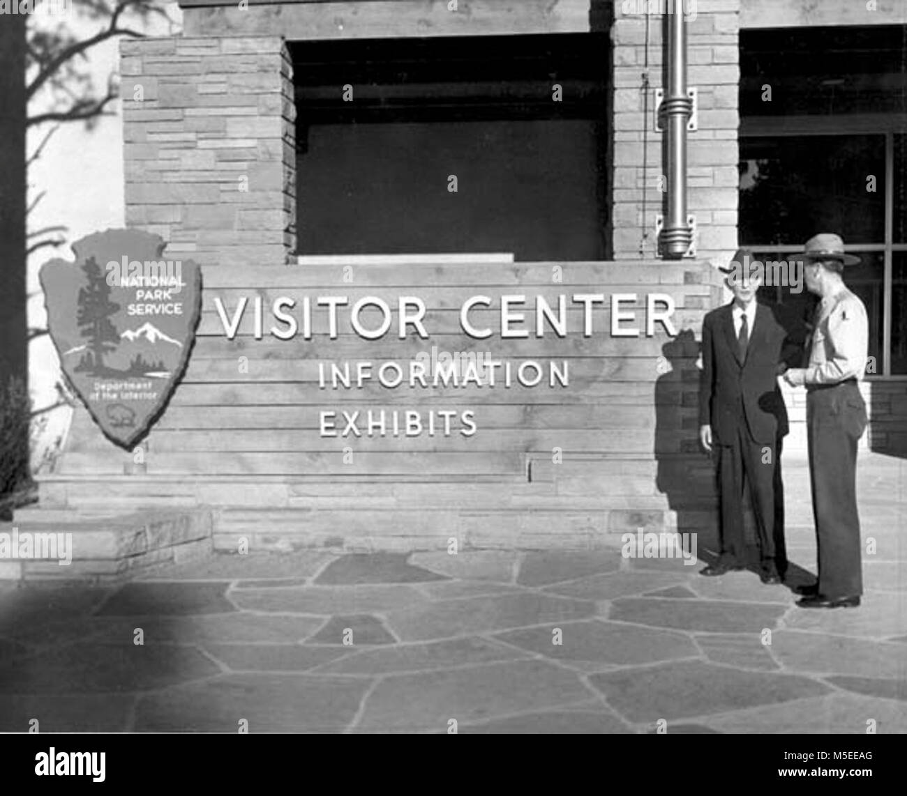 Grand Canyon- Carl Hayden   SENATOR CARL HAYDEN AND PARK SUPT. JOHN MCLAUGHLIN IN FRONT OF VISITOR CENTER. THE SENATOR HAS LONG BEEN A SUBSTANTIAL SUPPORTER OF THE PARK AND WAS PLEASED ON THIS OCCASION TO INSPECT A NUMBER OF PHYSICAL IMPROVEMENTS IN WHICH HE HAD PERSONAL INTEREST. WITH HIM WERE HIS ADMINISTRATIVE ASSISTANT PAUL K. EATON AND STAFF ASSISTANT ROY OLSON. MISSION 66 ERA. 17 SEPT 1958. , LEDING. Stock Photo