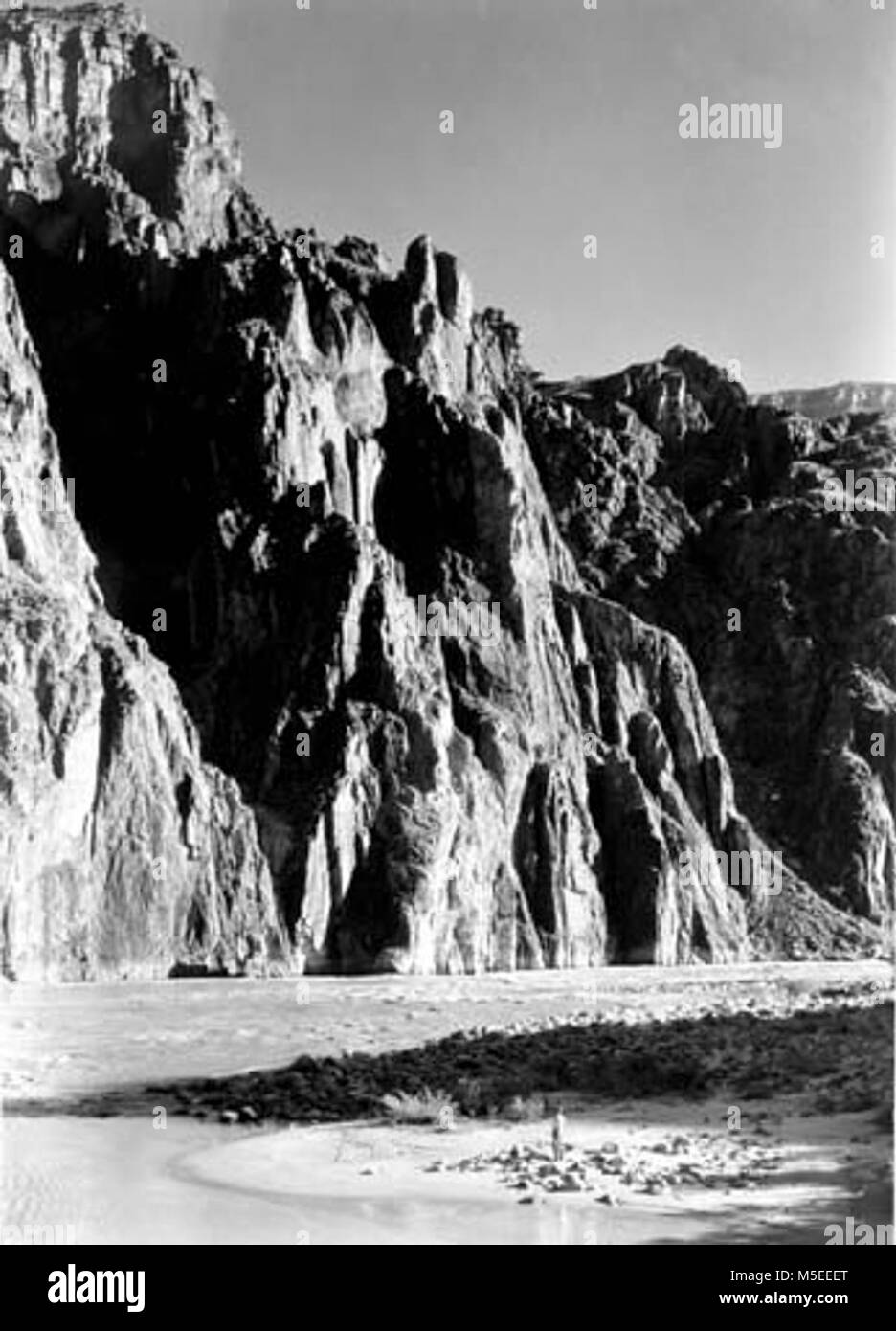Grand Canyon Historic- Phantom Ranch Scene c   NATURALIST, EDWIN D MCKEE STANDS ON COLORADO RIVER BEACH BELOW KAIBAB BRIDGE. CIRCA 1930. Stock Photo