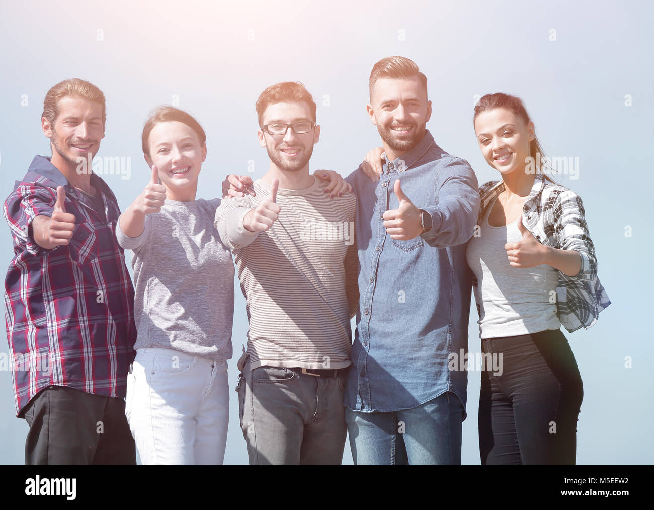 smiling group of young people showing thumb up Stock Photo - Alamy