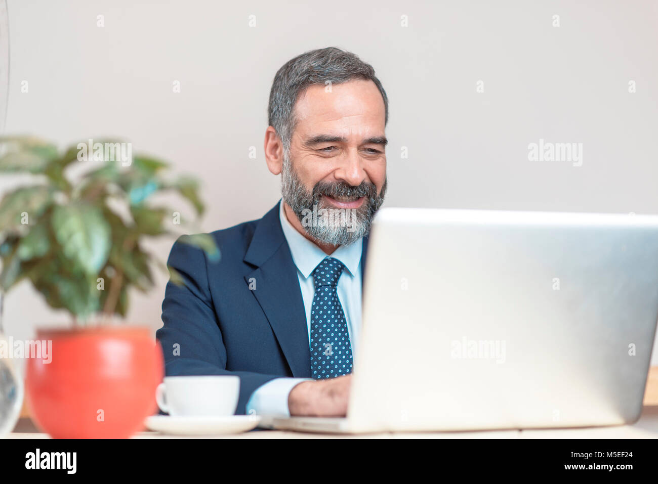 Senior old business man using his cell computer in a coffee shop during a work break Stock Photo