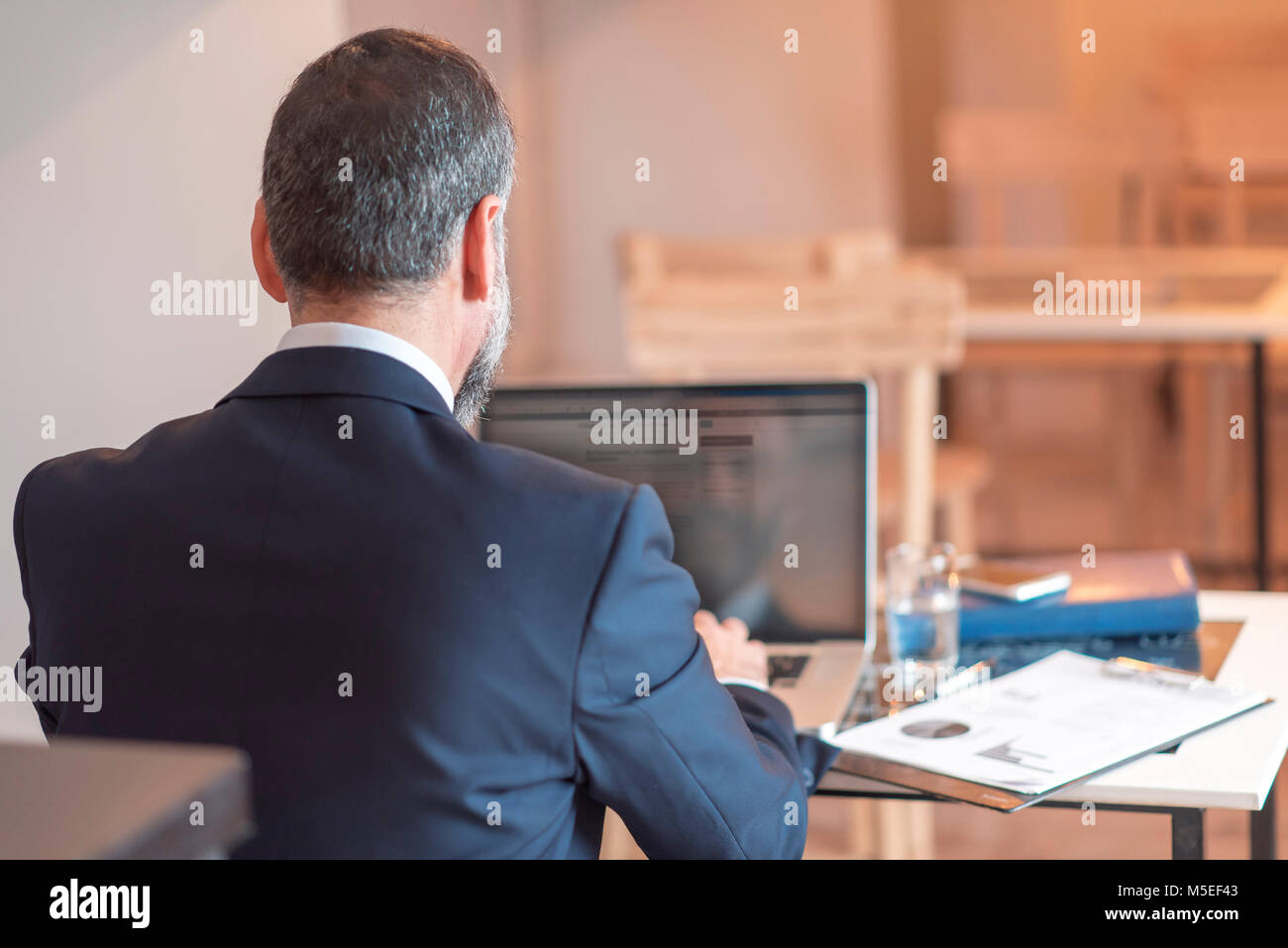 Senior mature business man having a coffee in a coffee shop and working on his computer Stock Photo