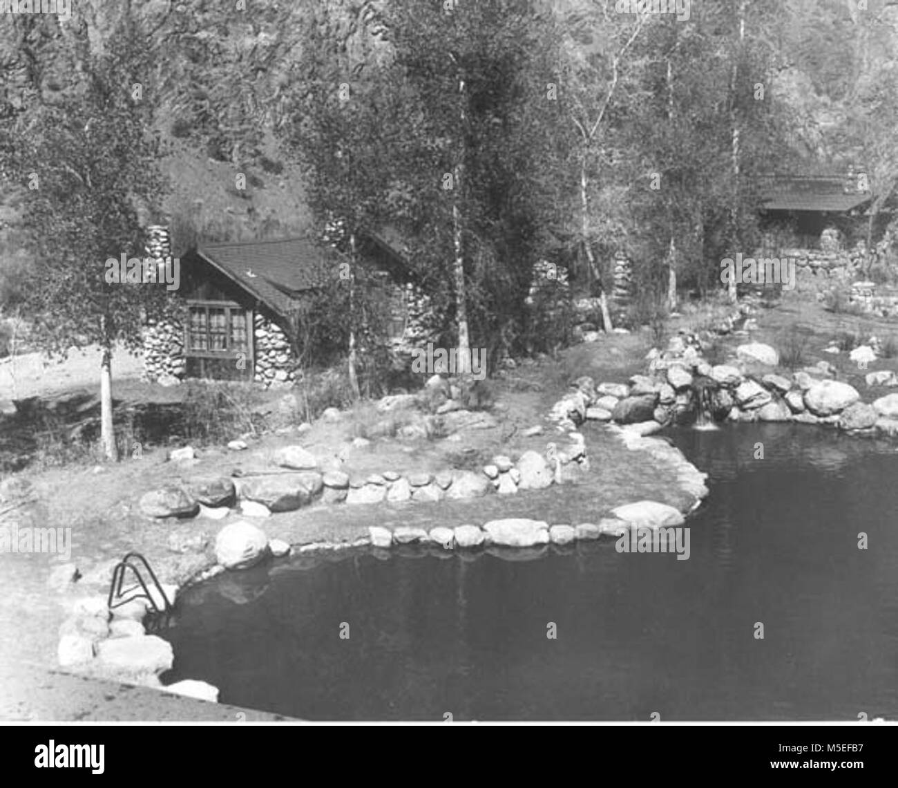 Grand Canyon Historic- Phantom Ranch Swimming Pool   OVERVIEW OF PHANTOM RANCH SWIMMING POOL WITH ENTRY LADDER AND WATERFALL WATER INLET. GUEST CABINS BEHIND. CIRCA 1965 . Stock Photo