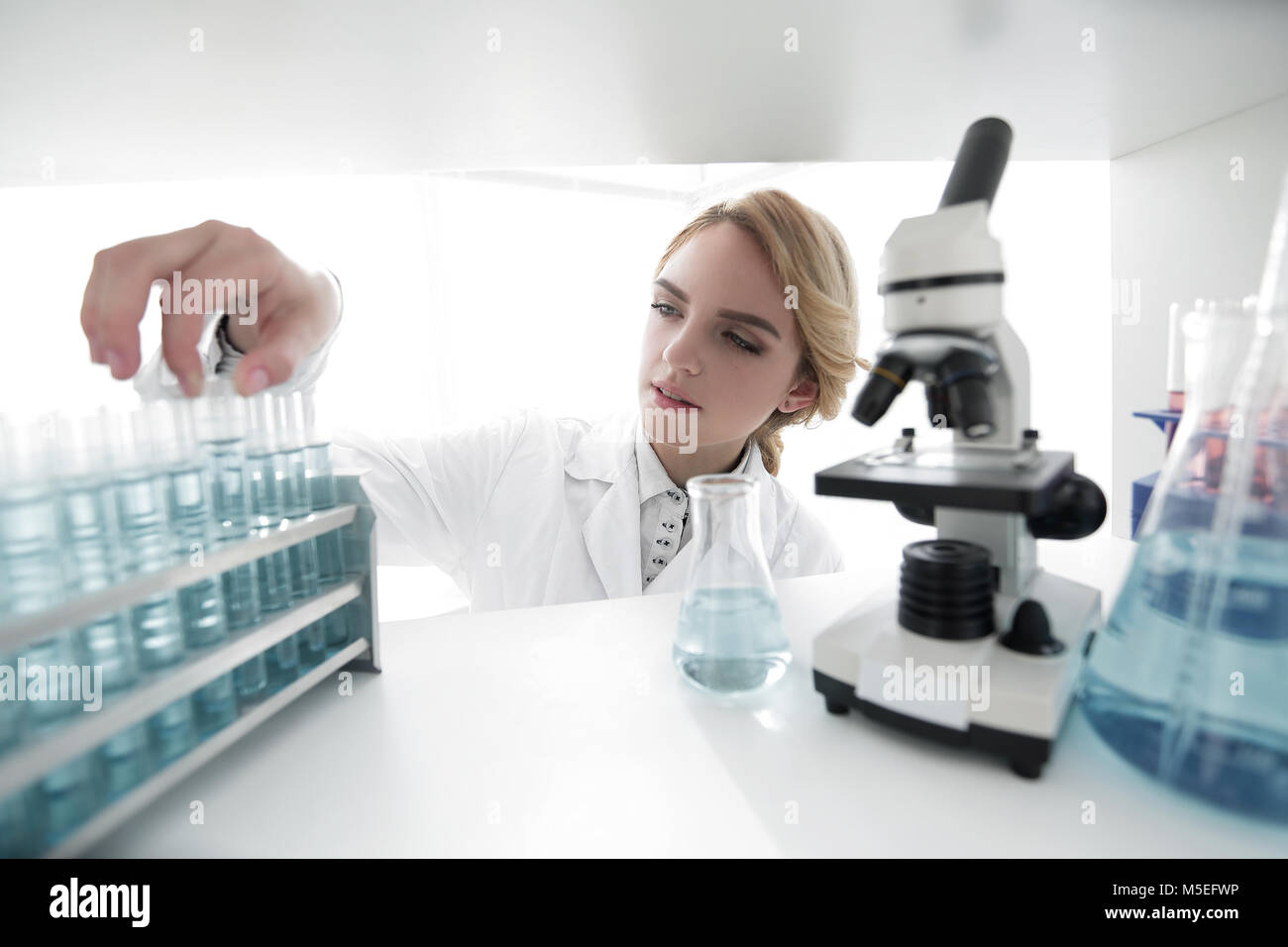 Young woman analyzing samples in a lab Stock Photo - Alamy