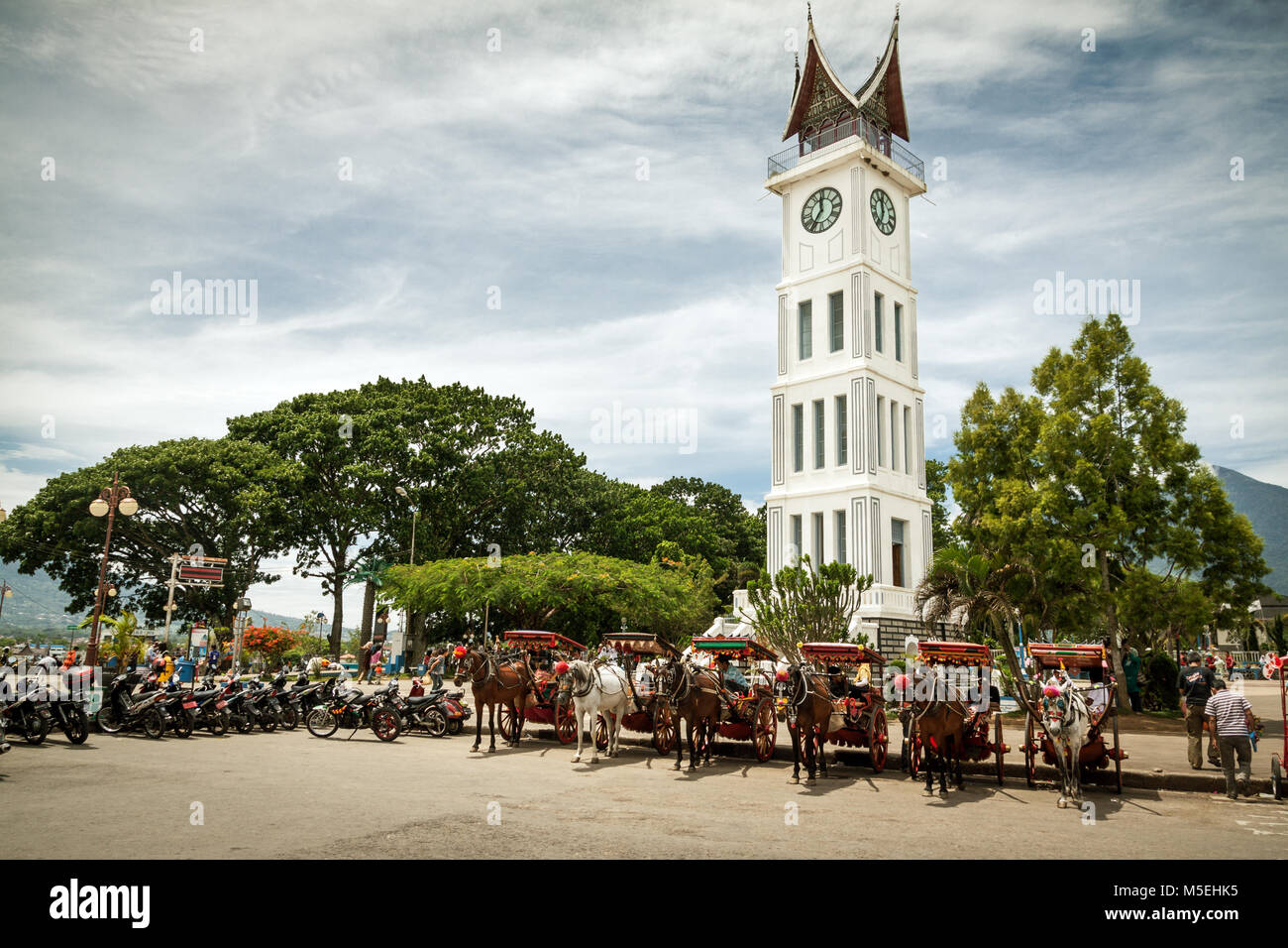 Famous clock tower of Bukittinggi, Jam Gadang in West Sumatra, Indonesia. Horse and carriages await below at this impressive tourist attraction Stock Photo