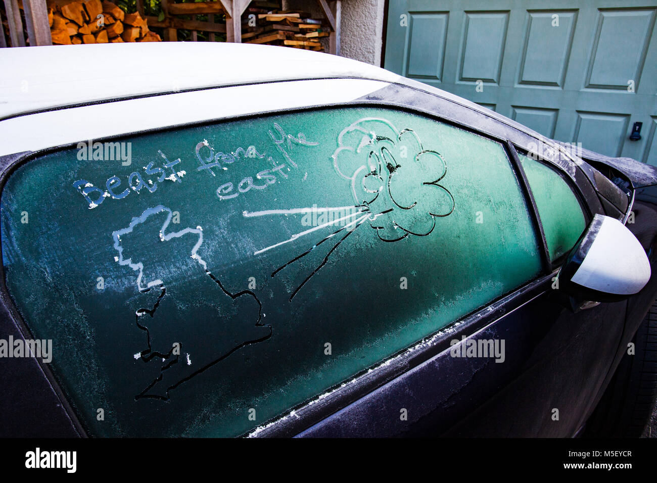 Car window with a drawn face cloud blowing air towards a map of the united kingdom or UK, Flintshire, Wales, UK Stock Photo