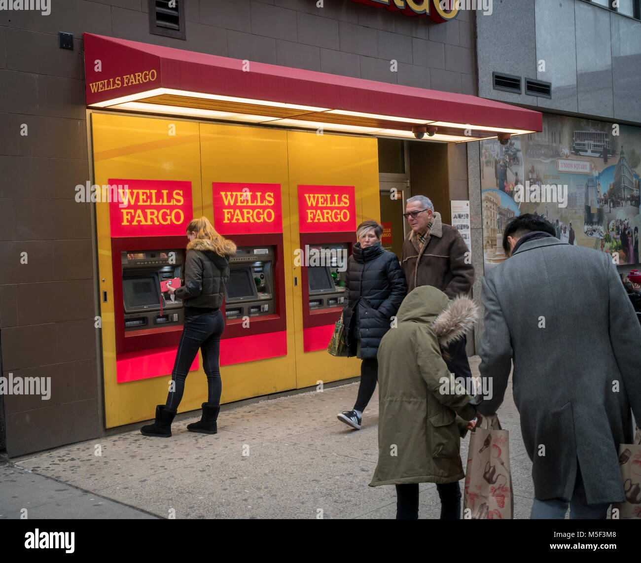 A woman uses a free standing Wells Fargo ATM in New York on Saturday