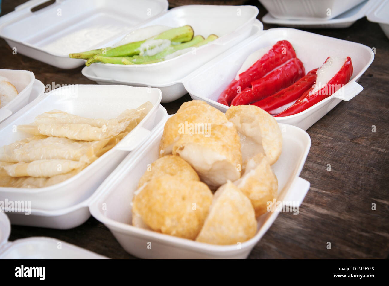 Malaysian packed lunch ideas culinary delights in Malaysia displayed on a table top ready to take away in polystyrene trays. Fast food for the workers Stock Photo