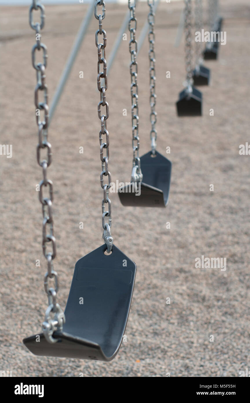 Row of rubber seat swings in a playground, vertical orientation Stock Photo Alamy