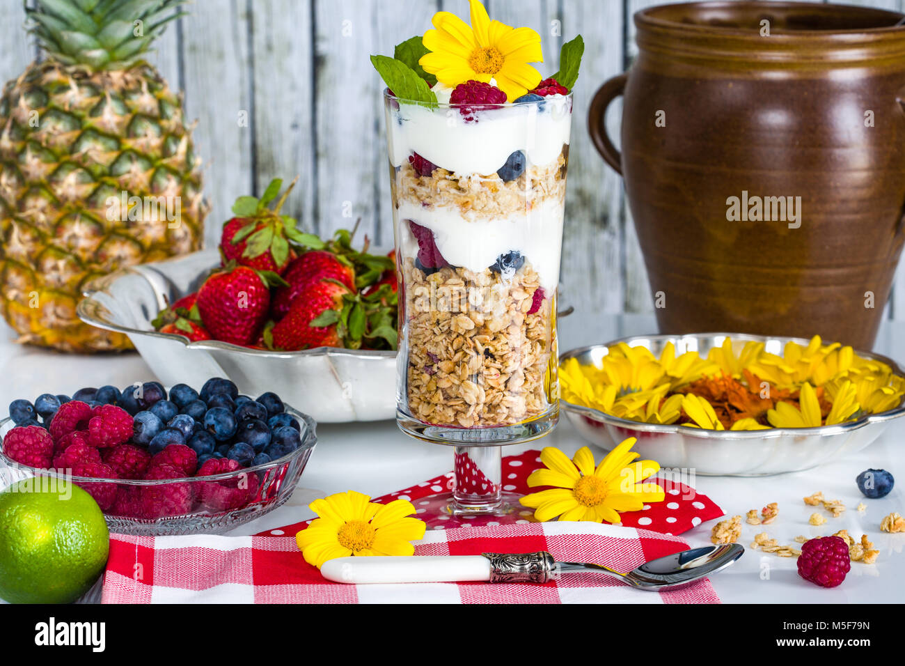 Fresh breakfast with muesli, yoghurt, fruit and edible flowers Stock