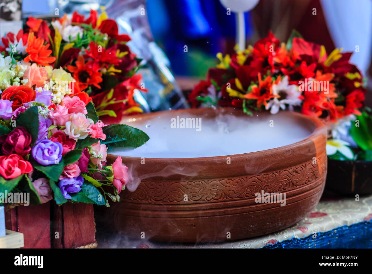 Beautiful decoration in spa shop with artificial flowers and dry ice smoke in the ceramic bowl. Stock Photo