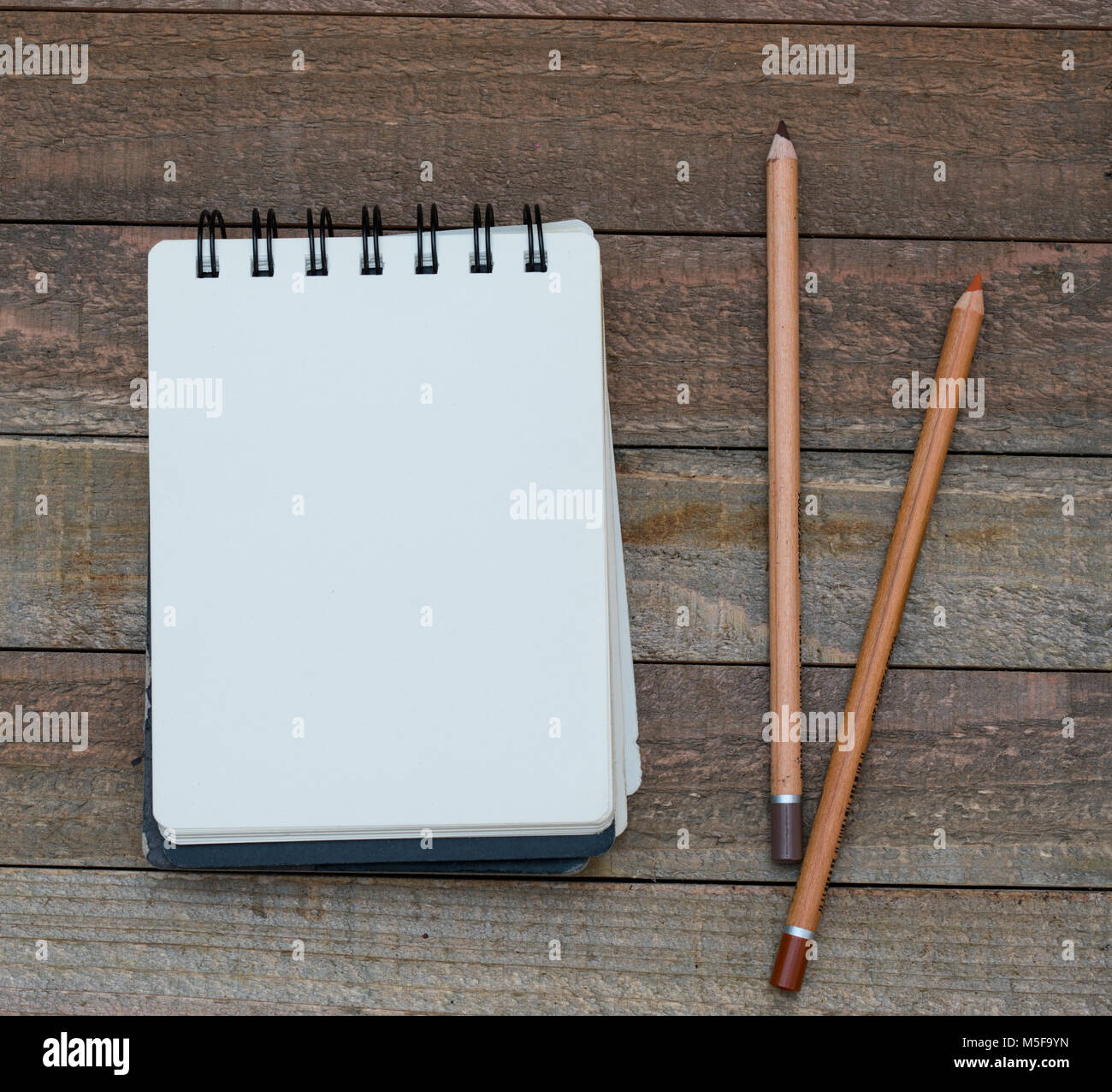 Clean unlined notepad laying on a wooden background with pencils Stock ...