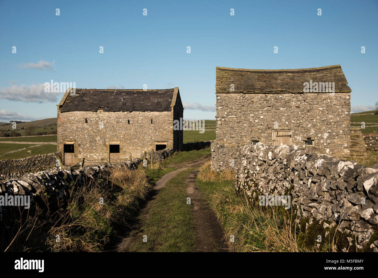 Twin old barns alongside a country lane near the village of Hartington