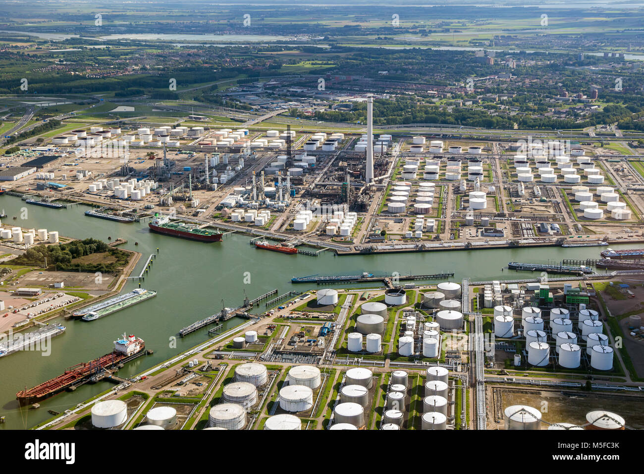 Aerial view of oil tankers moored at a oil storage terminal and oil refinery in a port. Stock Photo
