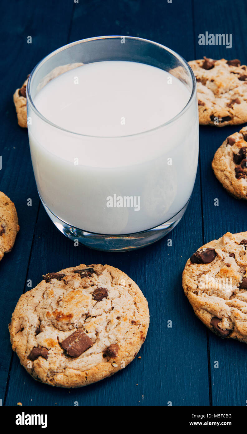 Chocolate chip cookies and glass of white milk on dark background Stock Photo