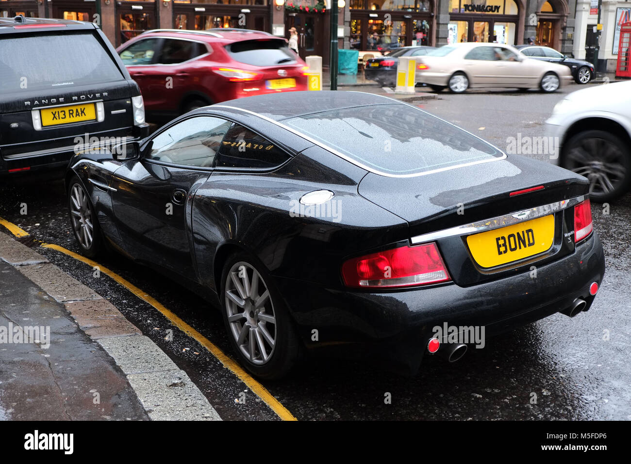 Aston Martin Vanquish parked in Sloane Square London. The owner has modified his E3 ONB number plate to read BOND after the Aston Martin driving Briti Stock Photo