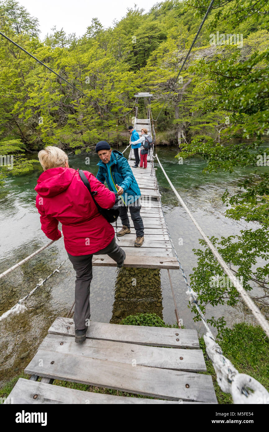 Trekker crosses footbridge over Rio del Vuetas; Lago Del Desierto; near Reserva Provincial Lago Del Desierto; Patagonia; Argentina Stock Photo