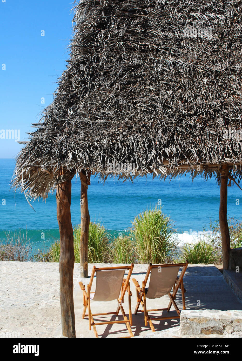 Under the Palapa - seating with a view to the sea Stock Photo