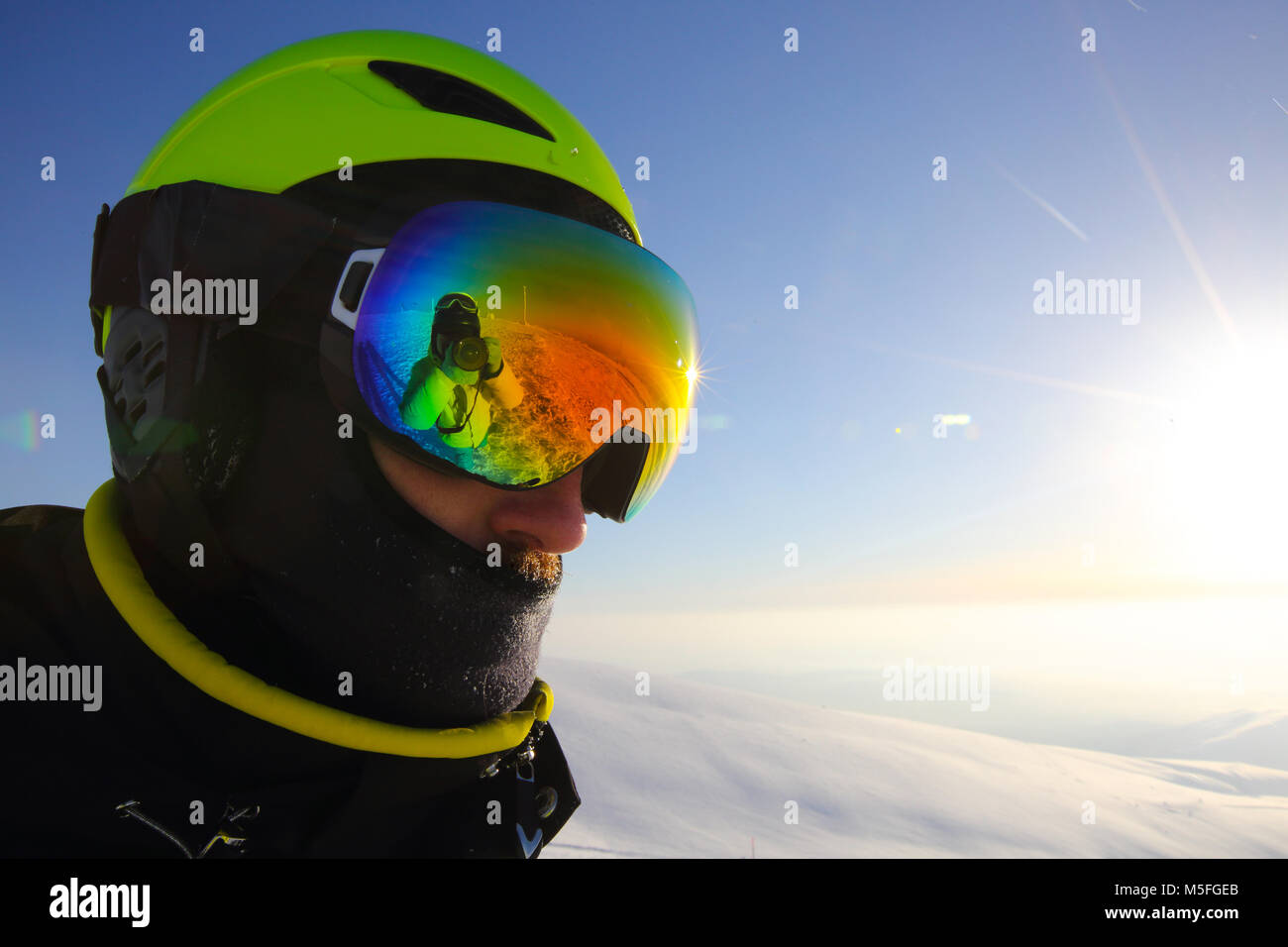 Skier wearing helmet and goggles in mountains close up portrait Stock Photo