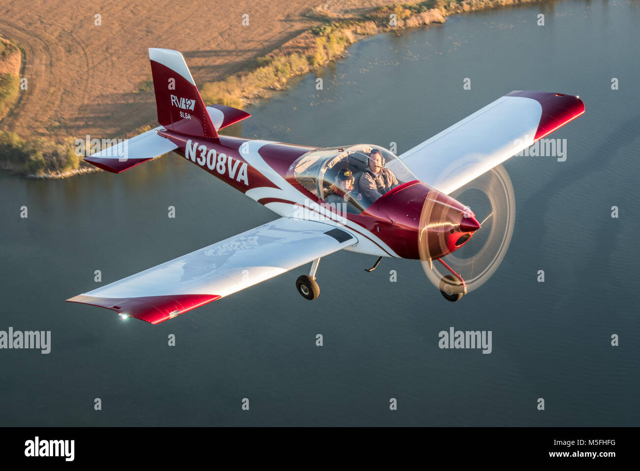 Male pilot operating blue Vans RV-12 light sport aircraft with female photographer flying over the Chesapeake Bay, Stevensville, Maryland. Stock Photo