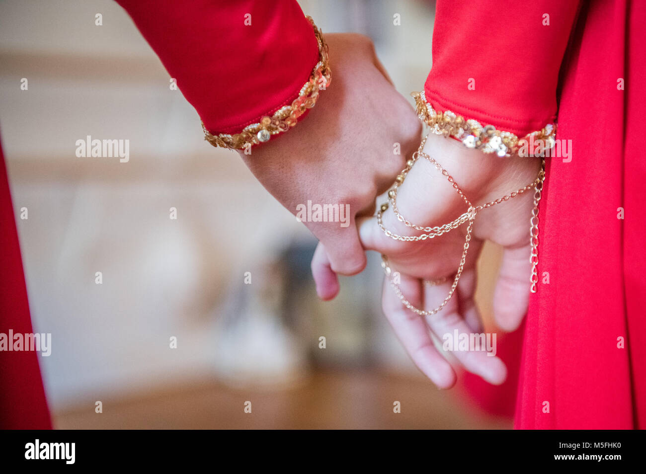 Two young girls with hand chain bracelet holding hands lovingly